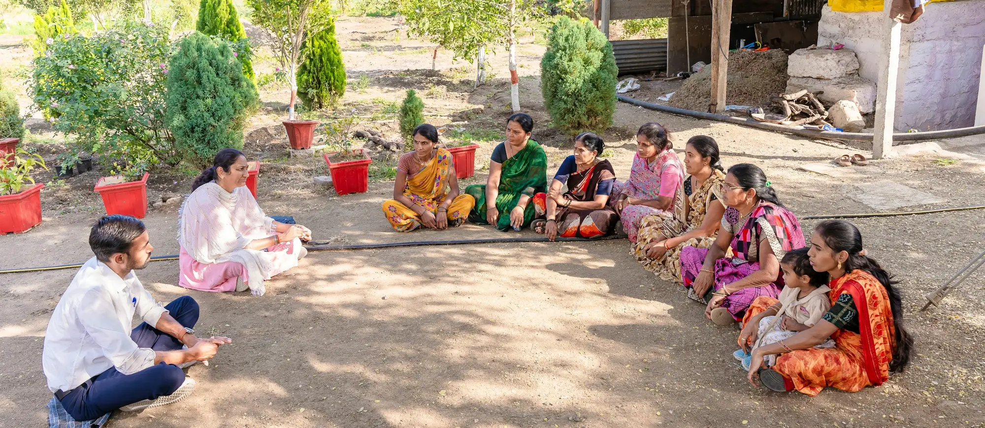 Village women sitting in a circle for a group meeting